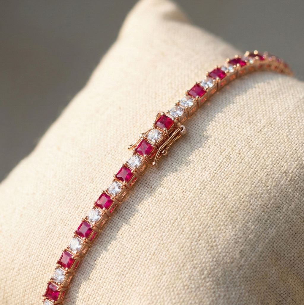 Bracelet with red gemstones and rose gold band on a beige surface