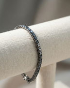Bracelet with black stones on a mannequin arm against a neutral background